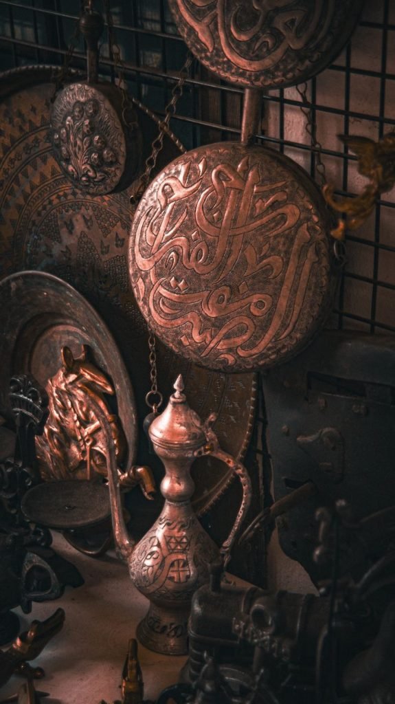 A collection of antique Middle Eastern brass artifacts featuring intricate calligraphy and designs.